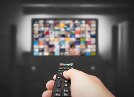 Hand using controller pointed at TV.