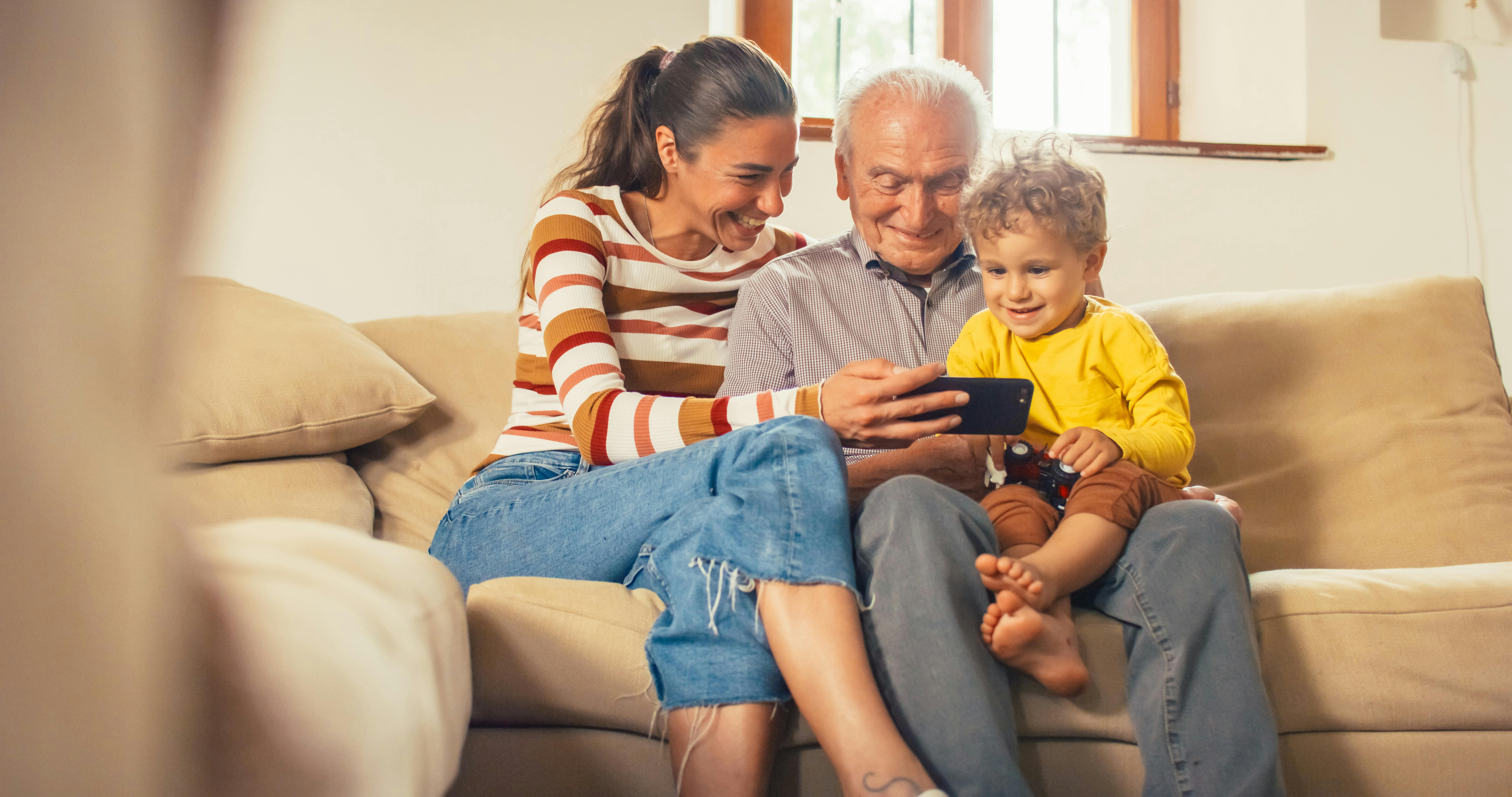 Family, mother grandfather and child looking at content on a phone