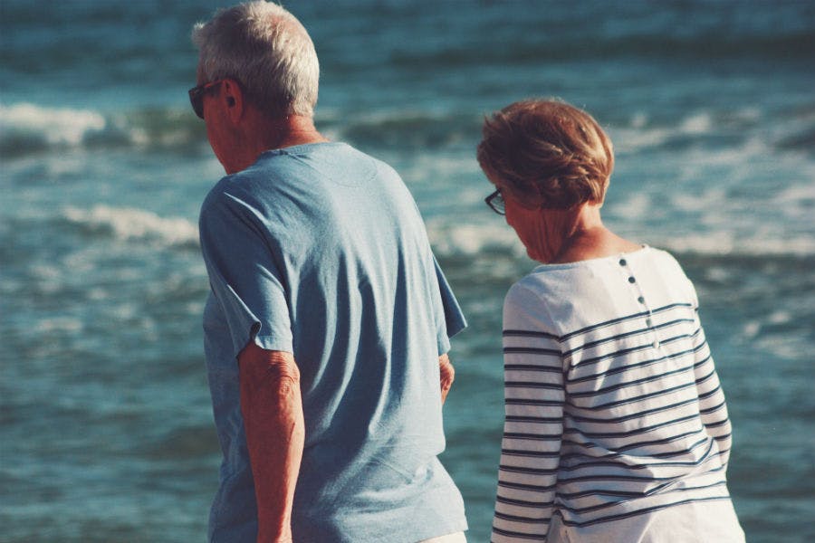 Elderly couple walking by the beach