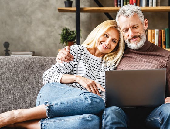 Man and Woman sitting on couch looking at computer