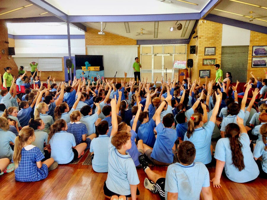 Children with their hands up in school
