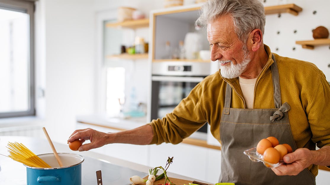 Older man cooking in kitchen