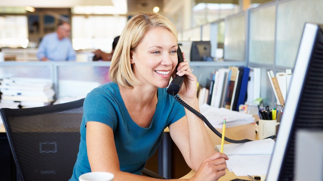 Lady using desk phone in office