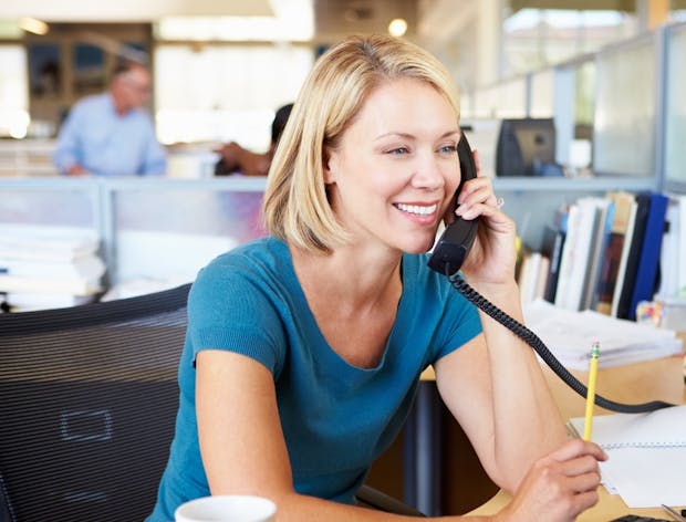 Lady using desk phone in office