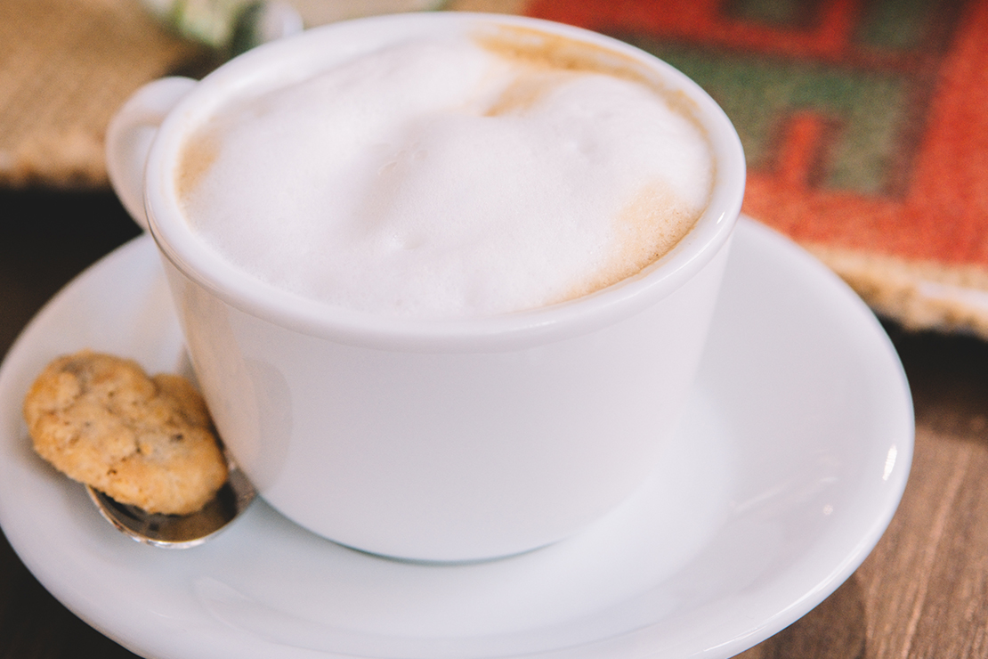 Man sieht eine Tasse mit Kaffee und Milchschaum.