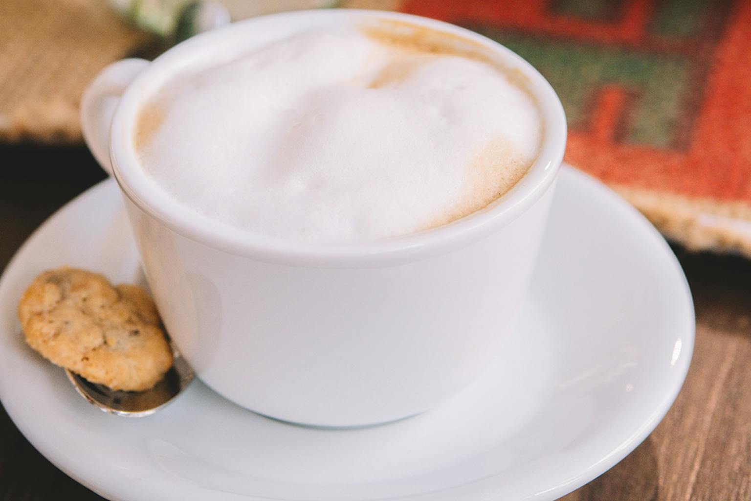 Man sieht eine Tasse mit Kaffee und Milchschaum.