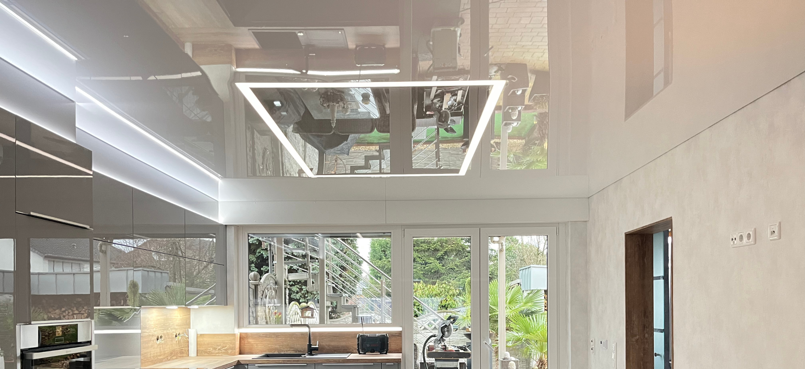 Spanndecken Markwoski - Ein modernes Wohnzimmer mit indirekter Beleuchtung und einer Spanndecke.