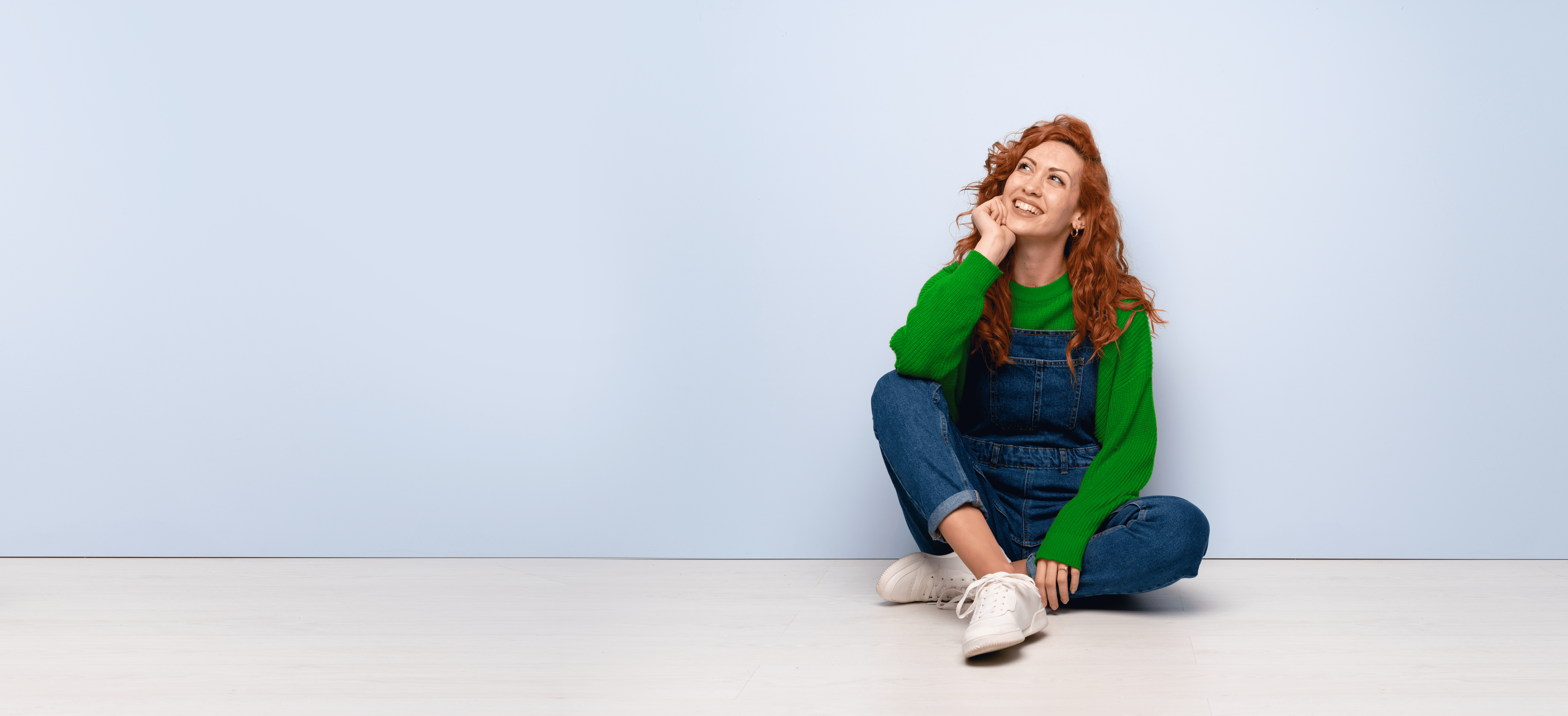 Frau in einem grünen Pullover guckt an eine Decke - Wissenswertes - Spanndecken Markowski GmbH