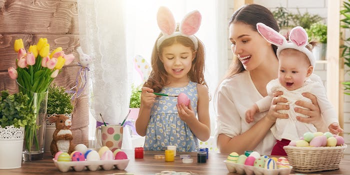 Ostern 2022: Rabatte und Deals für tolle Geschenke Eine Mutter bemahlt mit ihren Kindern Ostereier.