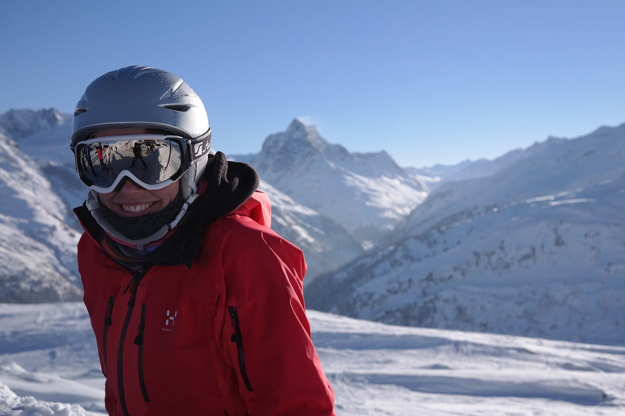 Hervis_Skier Frau mit Ski-Ausrüstung vor Berg-Kulisse