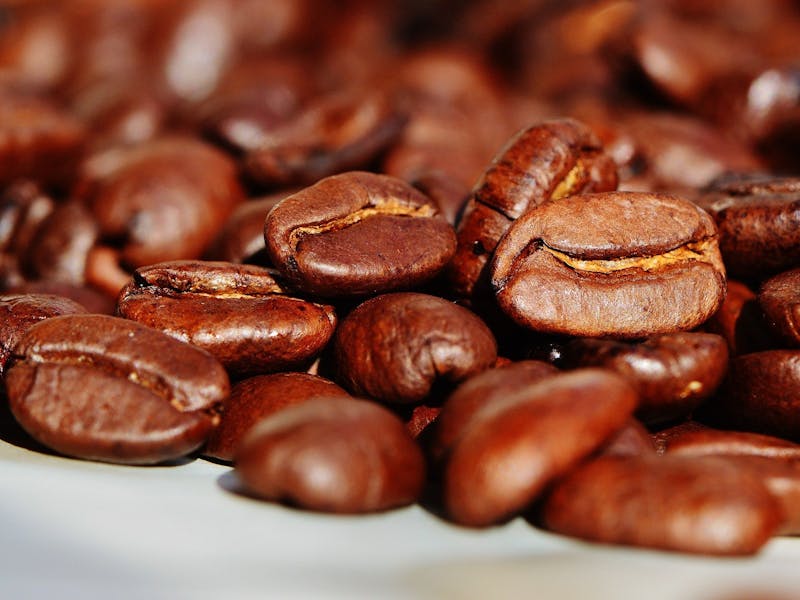 Mehrere Kaffeebohnen liegen aufeinander.