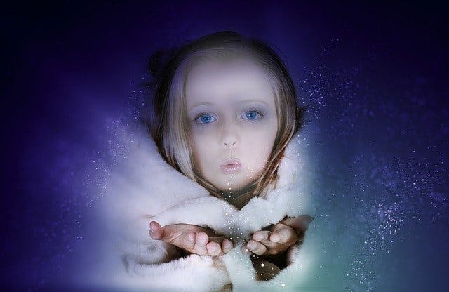 Mädchen pustet Schnee