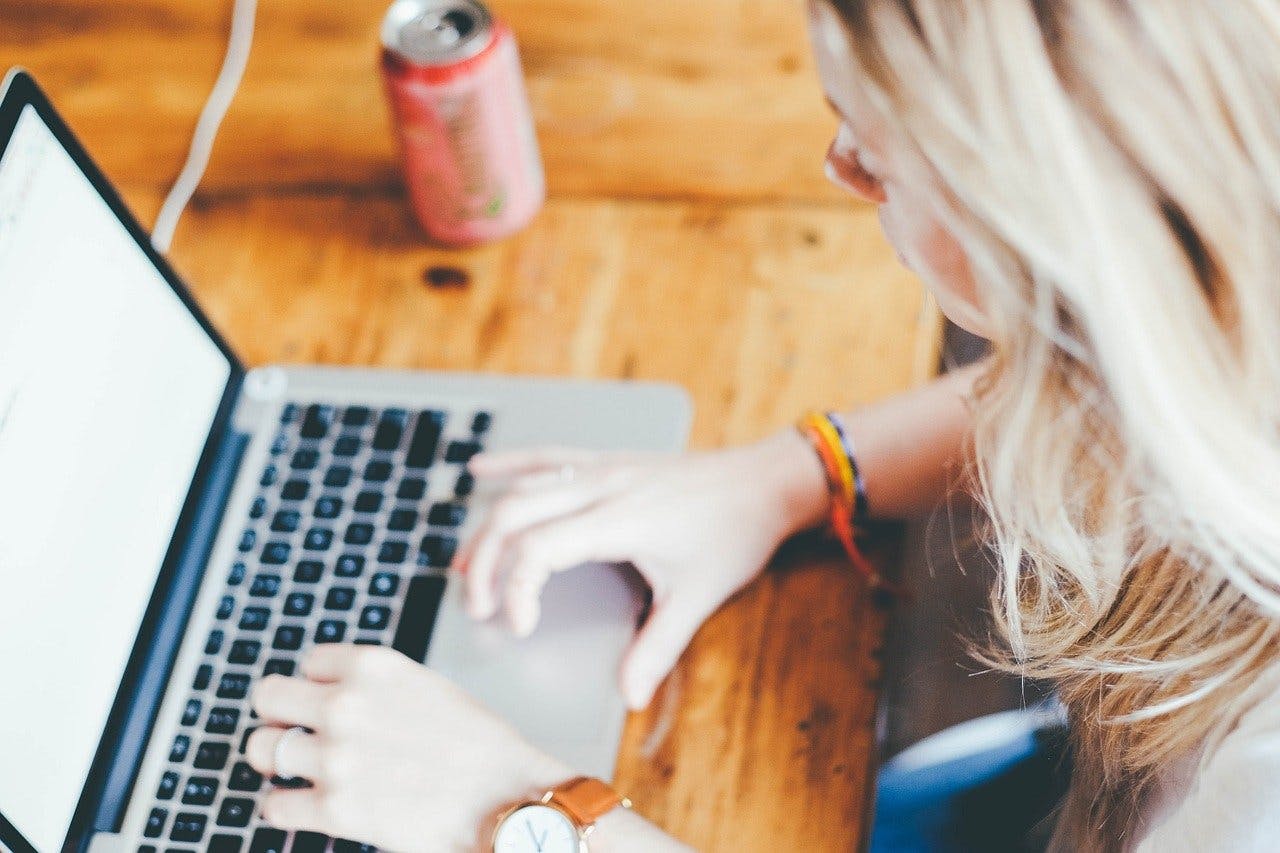 License-Now Gutschein Frau arbeitet an ihrem MacBook