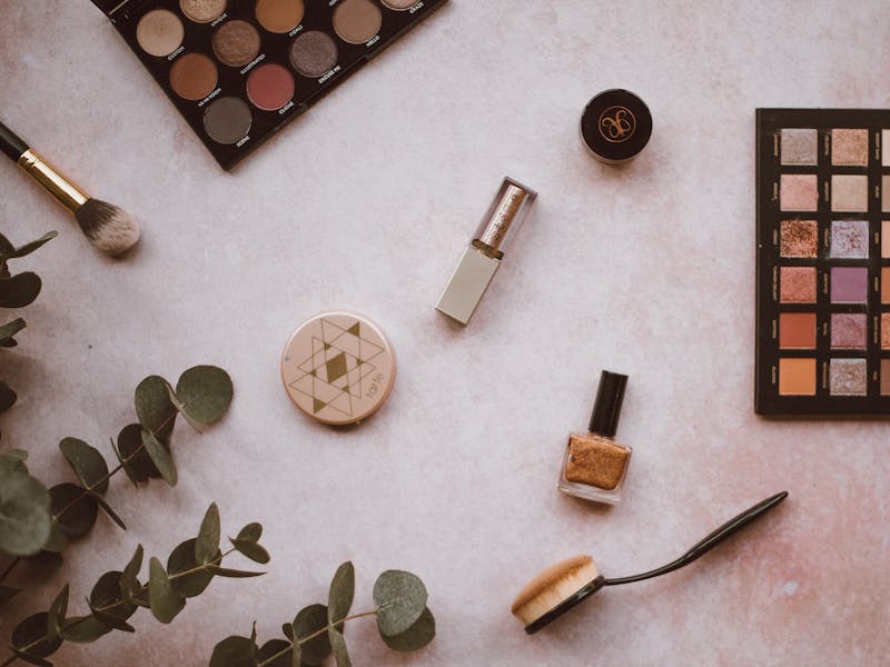 Lippenstift, Nagellack, Rouge und weitere Beauty-Artikel auf heller Oberfläche