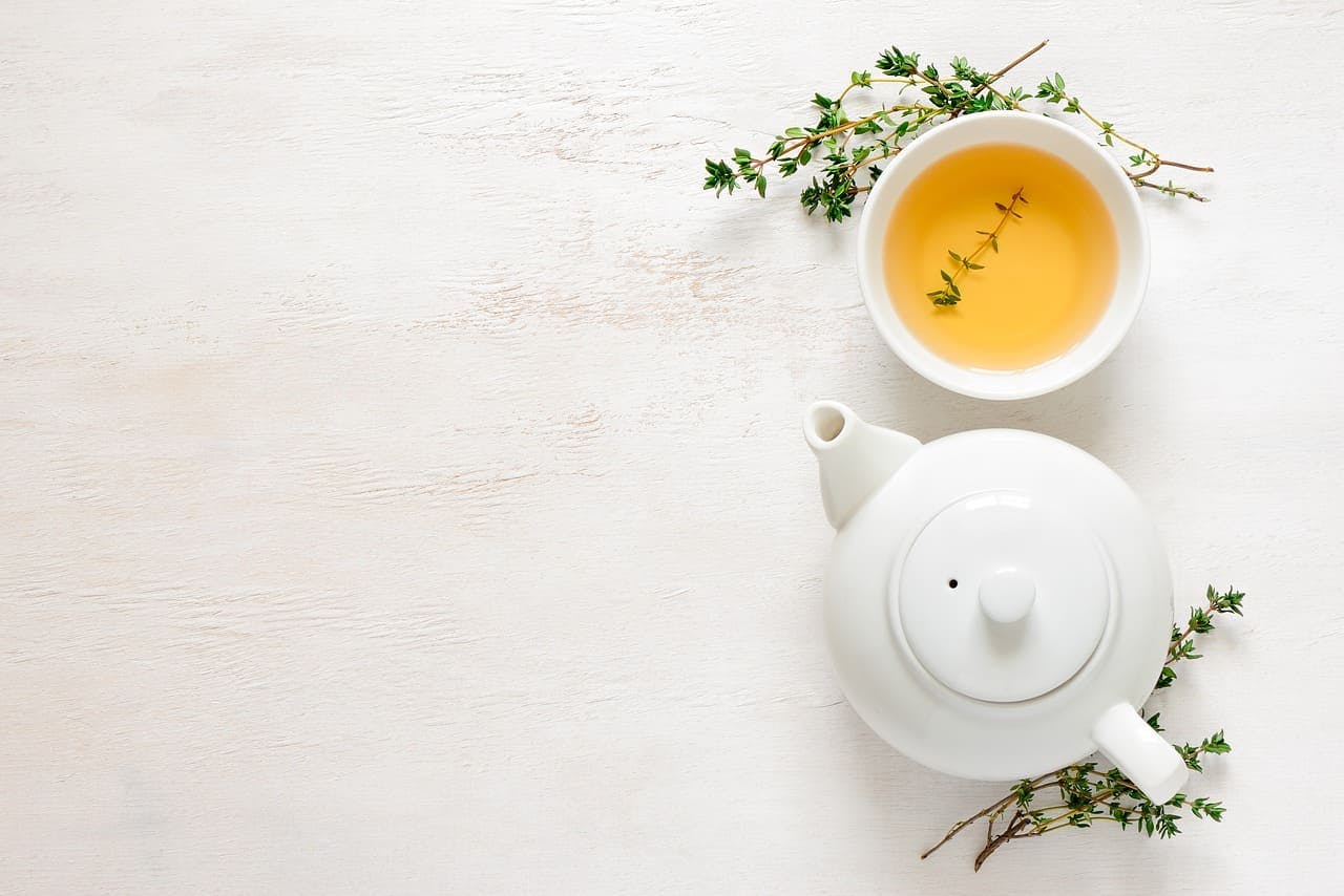 Kräuterhaus_Sanct_Bernhard_Tee Teekanne und -tasse mit Kräuterzweigen