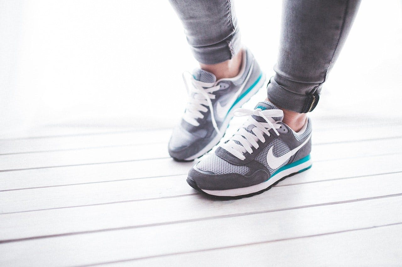 Dosenbach_Sneakers Mann mit grauen Nike-Schuhen mit türkisem Streifen