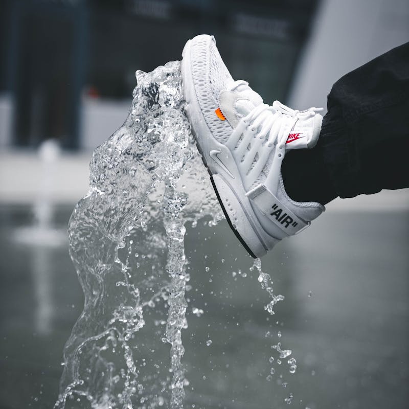 Mensch mit Sneaker an Wasserfontäne