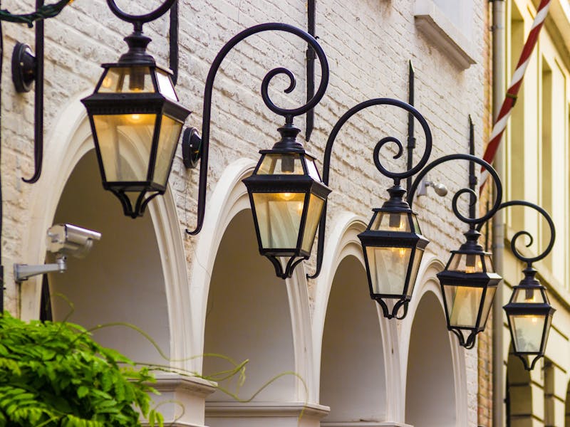 Mehrere Lampen an einer Hauswand.