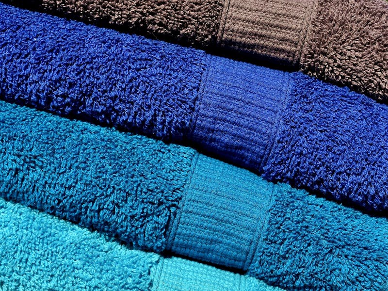 Ein paar Handtücher in Blau-Tönen liegen aufeinander