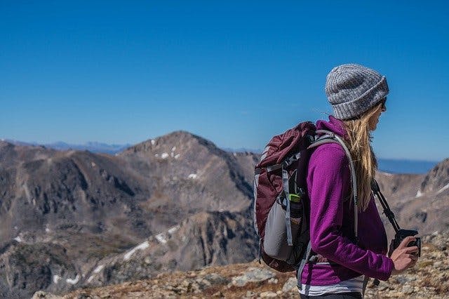 Frau mit Rucksack wandert in den Bergen