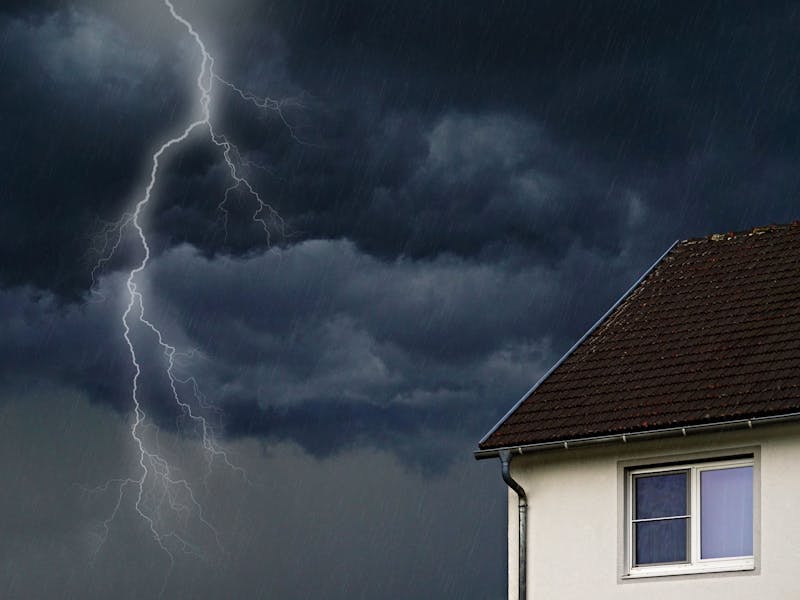 Ein Haus, neben dem ein Blitz zu sehen ist.