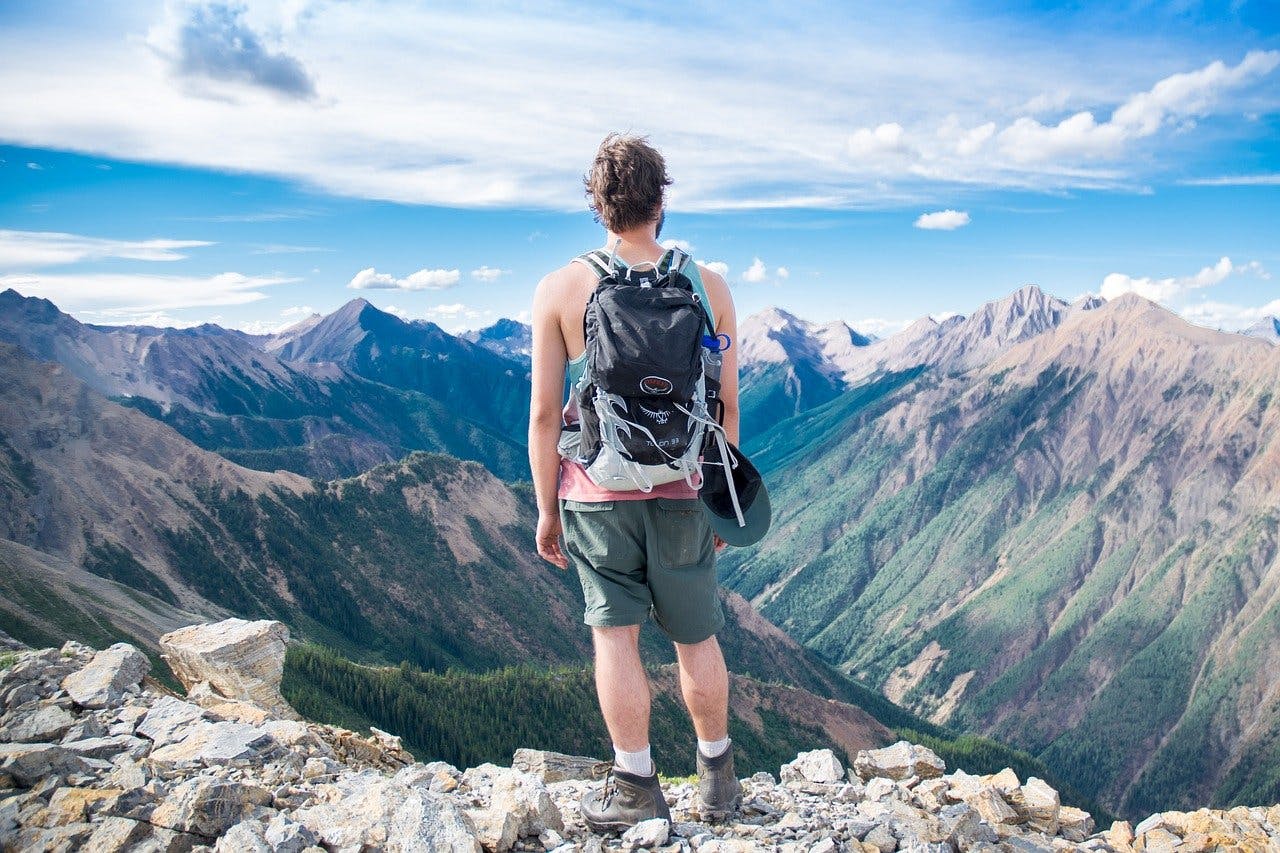 Outdoor Gutschein In Outdoor Kleidung gehüllter Mann genießt die Aussicht auf ein Bergpanorama
