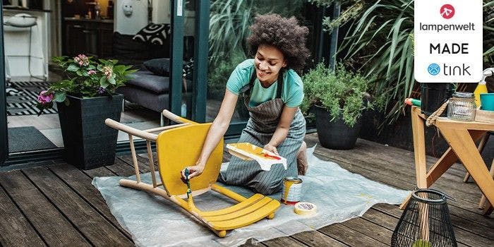 Für ein schönes Zuhause: Gutscheine für Haus & Garten Frau malt einen Stuhl auf der Terrasse an