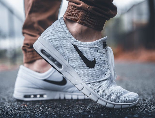 size GDE weiße Sneaker Mann mit brauner Hose und weißen Sneakers von Nike