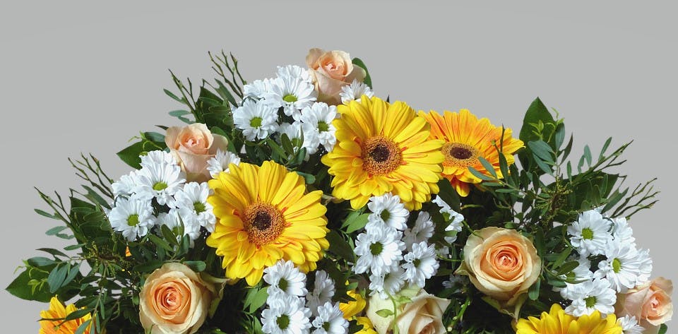 Fleurop Blumenstrauß Blumenstrauß mit Blättergrün, gelben und weißen Blumen und gelben Rosen