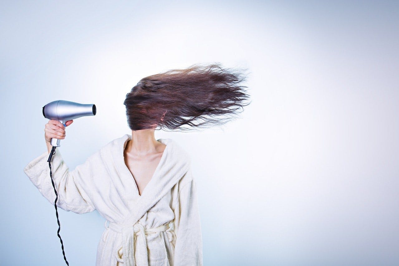 Dyson Haartrockner Frau fönt sich die Haare
