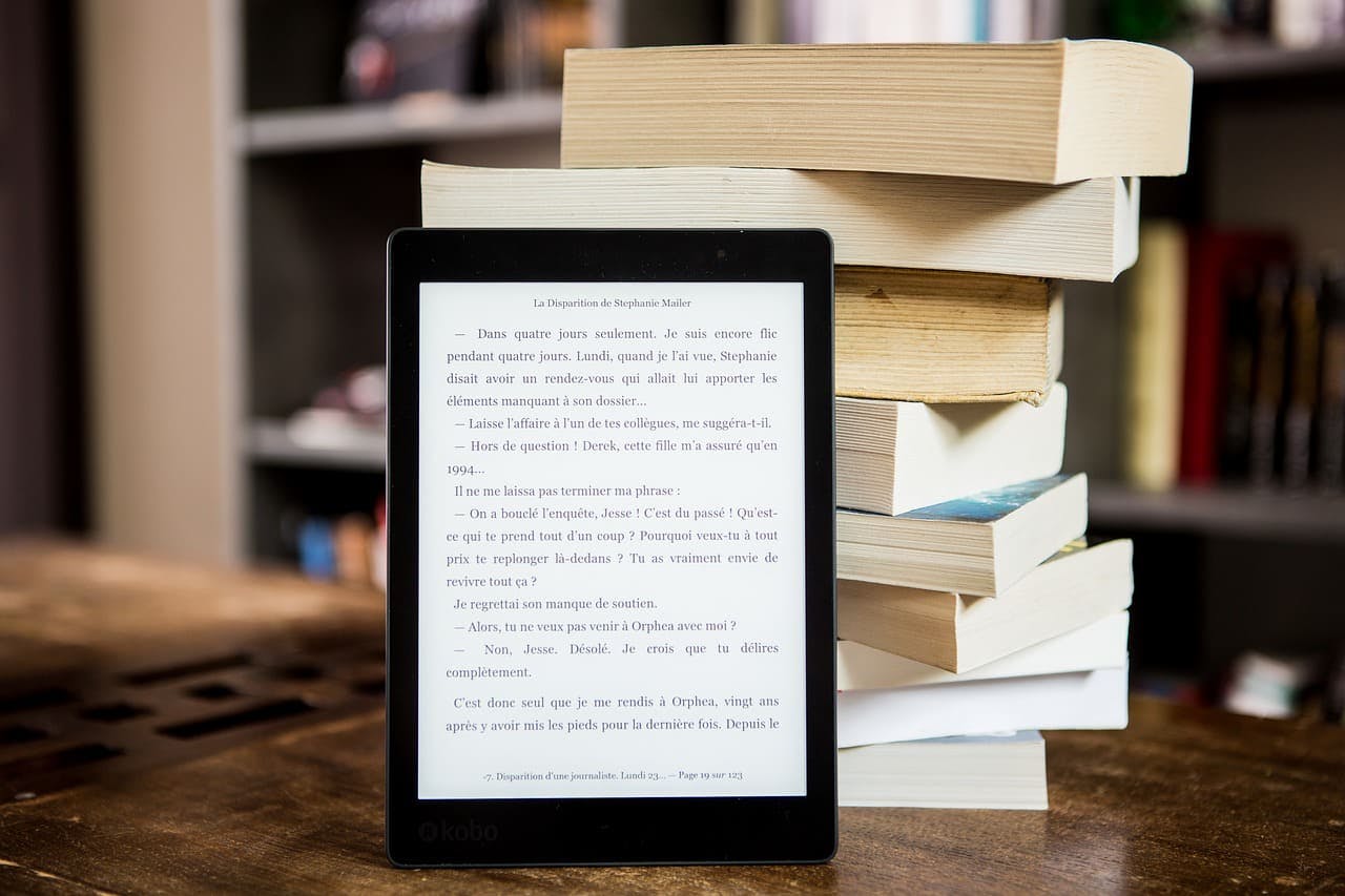 amazon_ebook eReader angelehnt an einen Bücherstapel