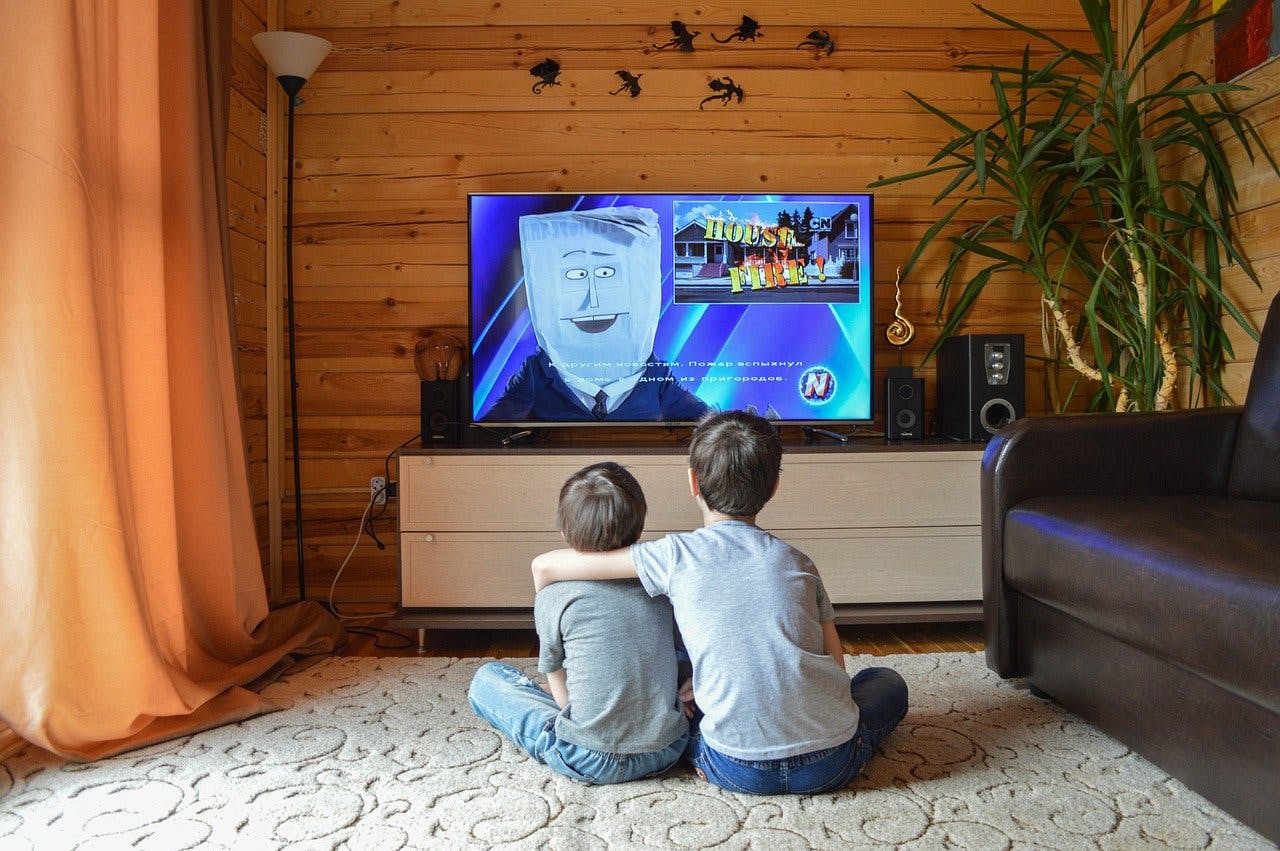 TV Gutschein Zwei Jungen sitzen vor dem Fernseher