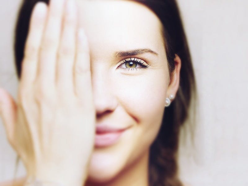 Frau mit der Hand vor dem Gesicht