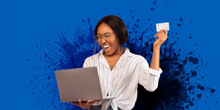 Singles' Day - Die besten Gutscheine und Angebote Eine junge Frau trägt einen Computer, hält eine Kreditkarte hoch und zwinkert.