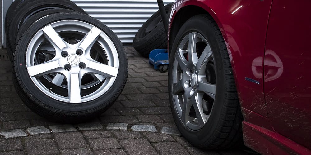 Rotes Auto mit Reifen für den Reifenwechsel