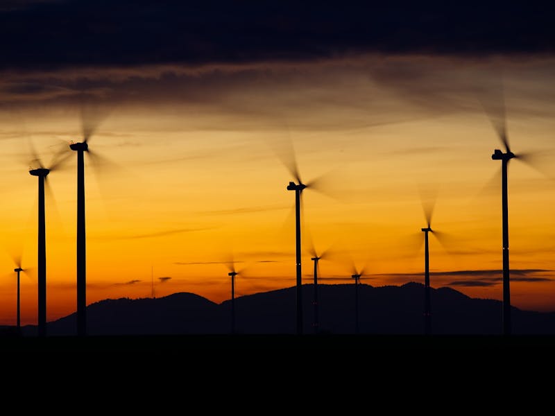 Mehrere Windkraftanlagen im Sonnenuntergang.