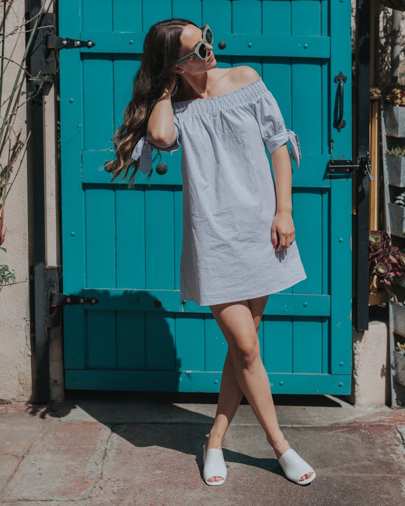 Frau mit Sonnenbrille in hellblauem Kleid