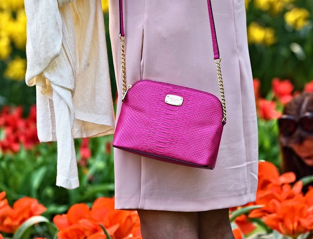 Vestiaire Collective GDE Frau in rosa Mantel mit pinker Designer-Tasche