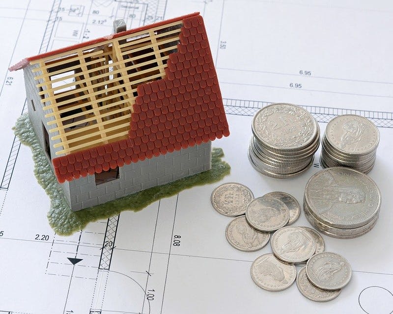 Check24 Kredit und Finanzierung Modellhaus und Münzen