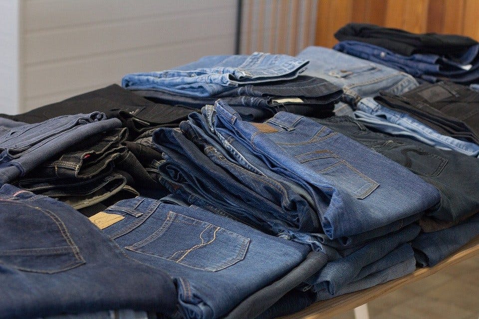 Breuninger Jeans Gefaltete Jeanshosen auf Verkaufstisch