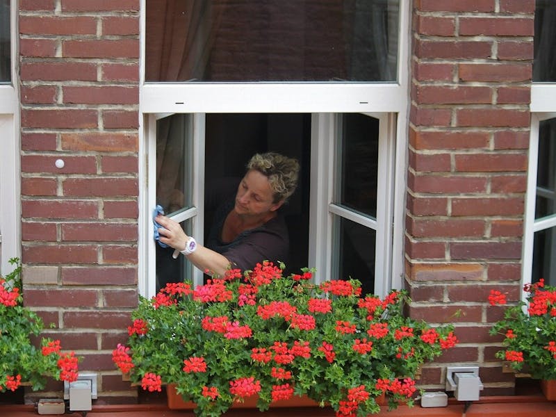 Frau beim Fensterputzen