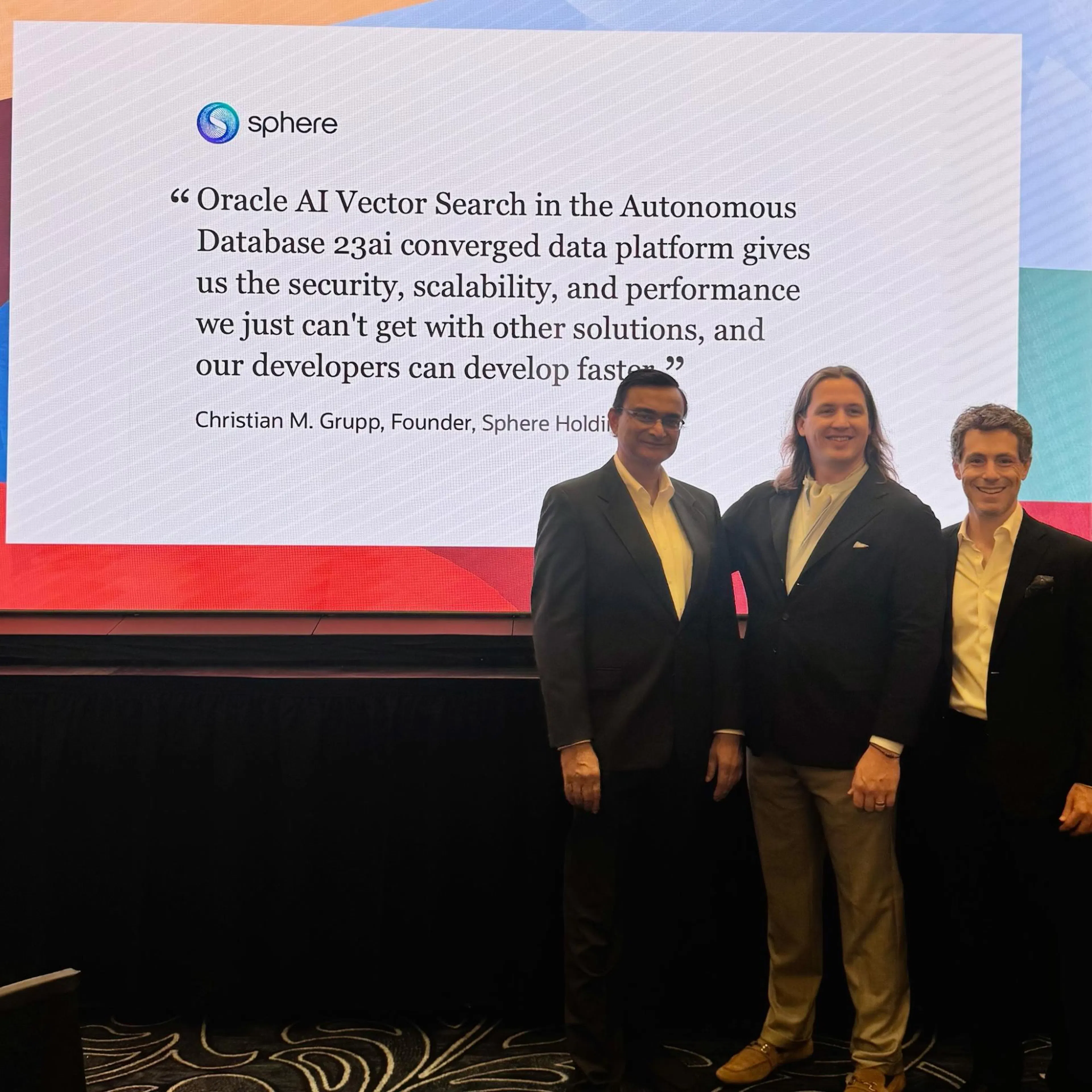 Christian Grupp with two colleagues in front of a Sphere slide at Oracle AI World 2025 quoting him on Oracle AI Vector Search in Autonomous Database 23ai.
