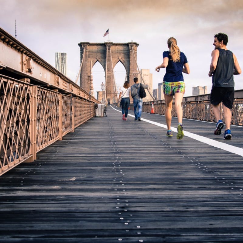 People running on a bridge at daylight