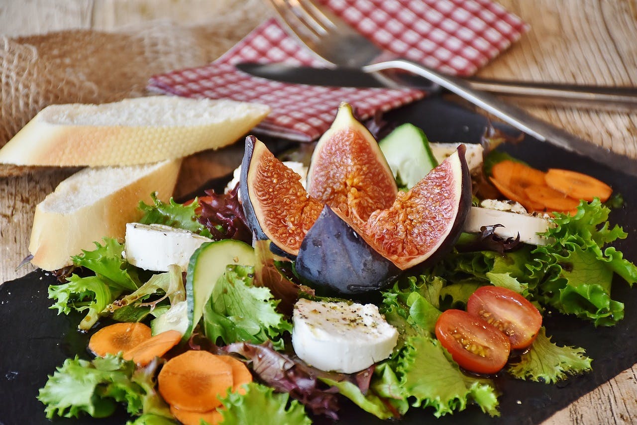 Close-up of vegetable salad and slices of bread on a board