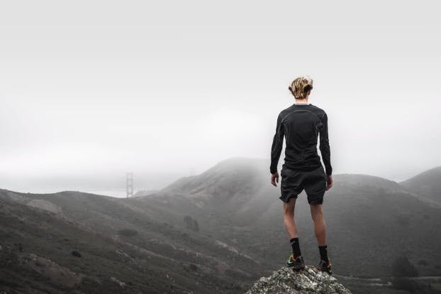 Blonde man standing on a cliff