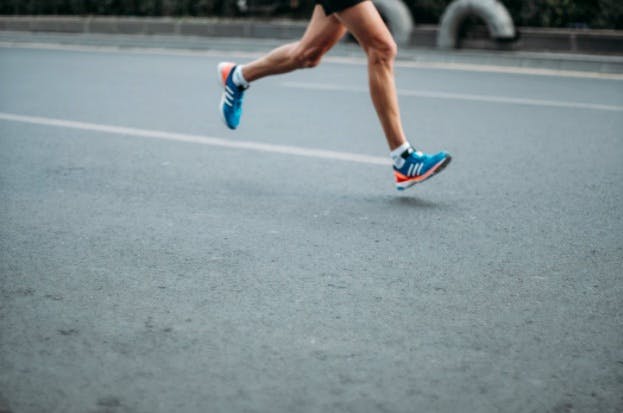A man running on the street with proper running form and shoes