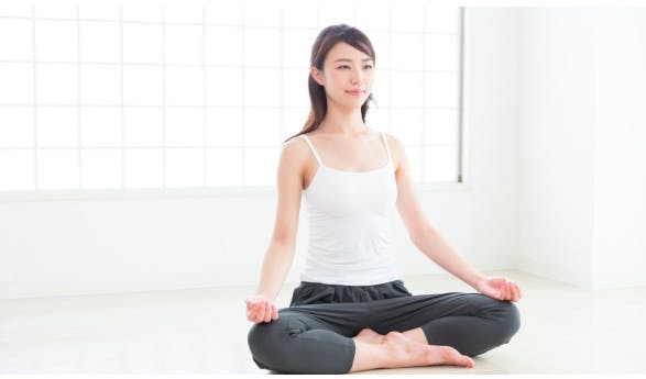 Woman relaxing in the easy pose to address her knee pain