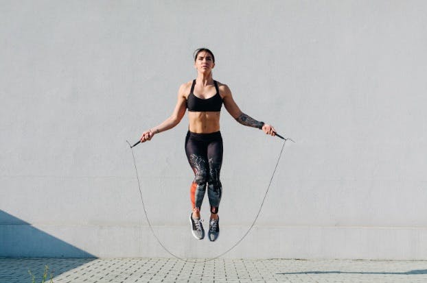 Woman jump roping as dynamic stretch before running 