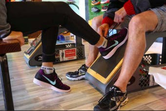 Close-up of man and woman's legs, wearing training shoes, at the gym