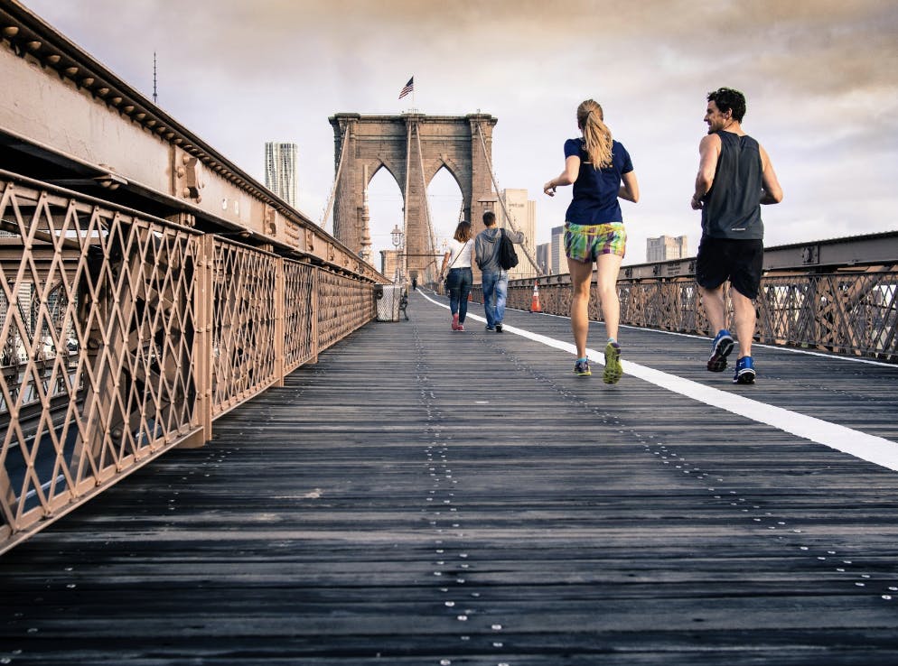 Woman and man running on bridge